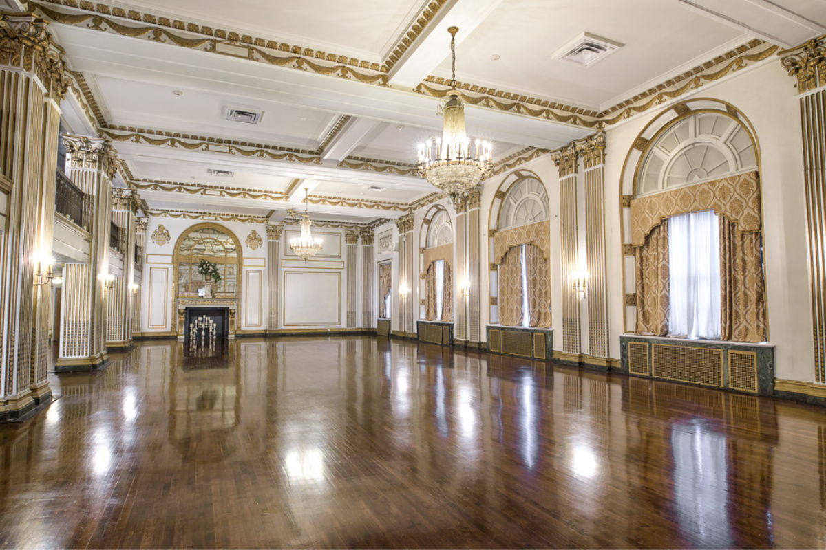 a large room with a chandelier and a wood floor