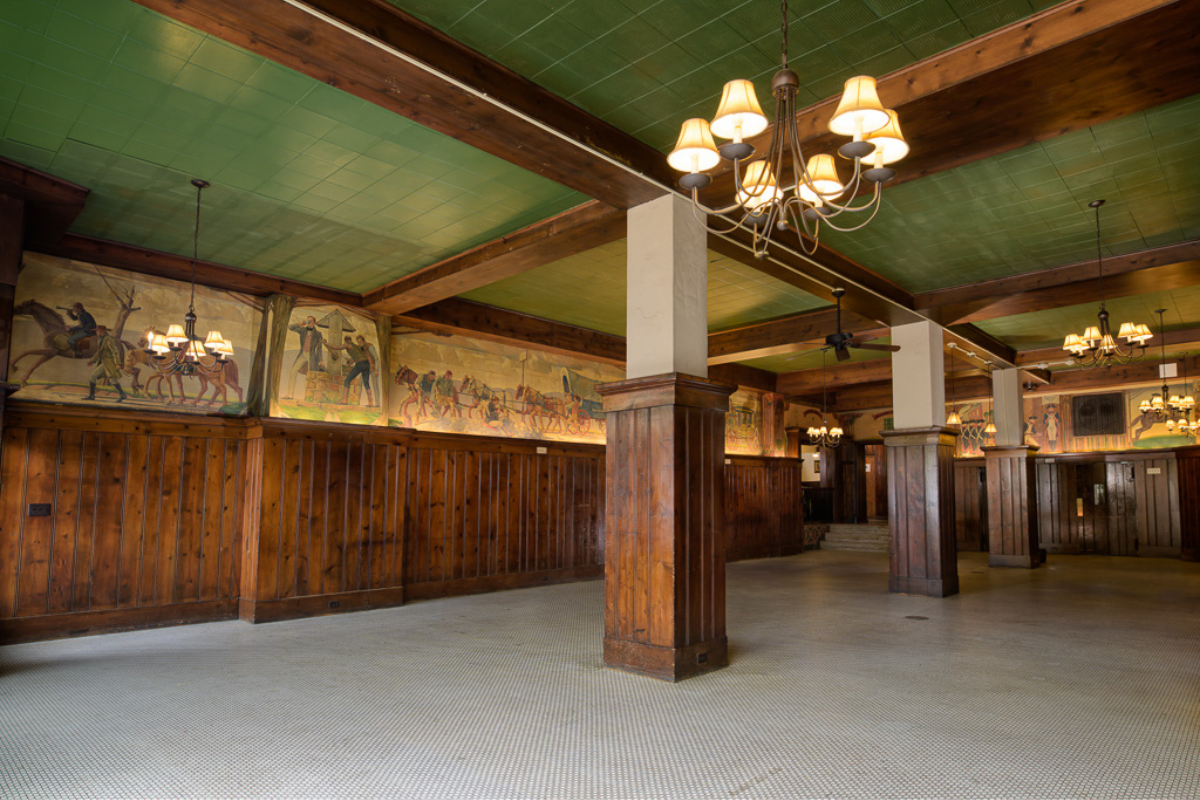 a room with wood columns and a chandelier