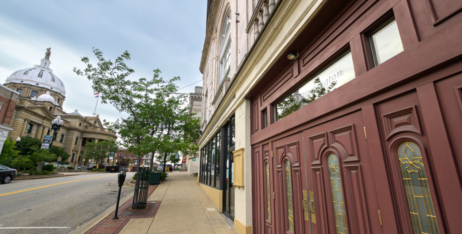 a sidewalk with a building and trees