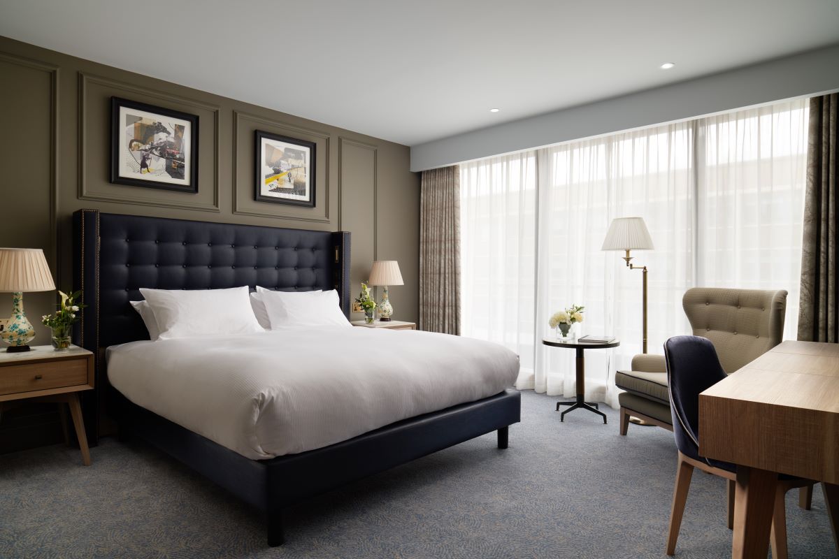 a room with a bed and chairs