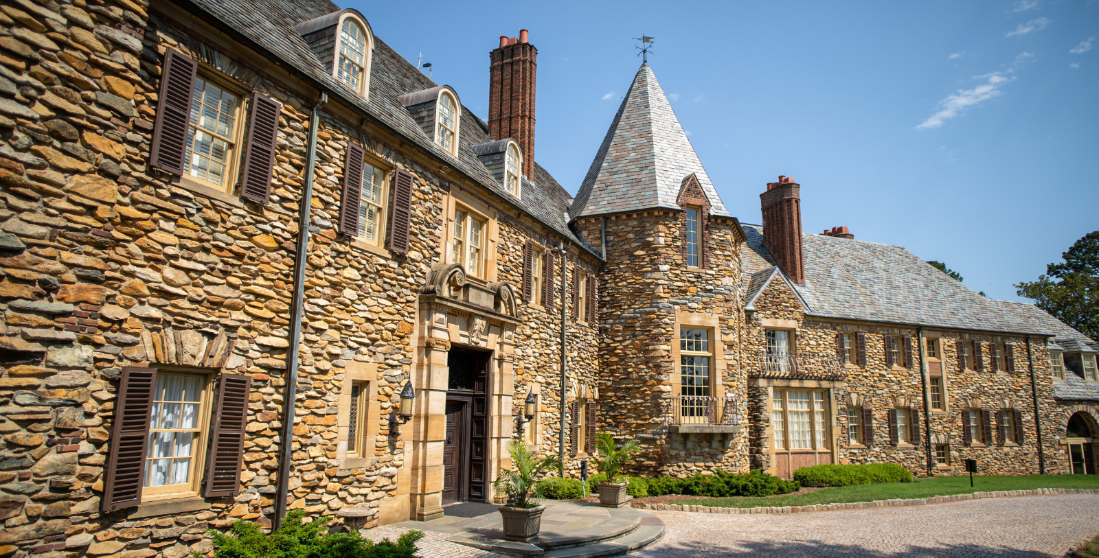 a large stone building with a round stone walkway