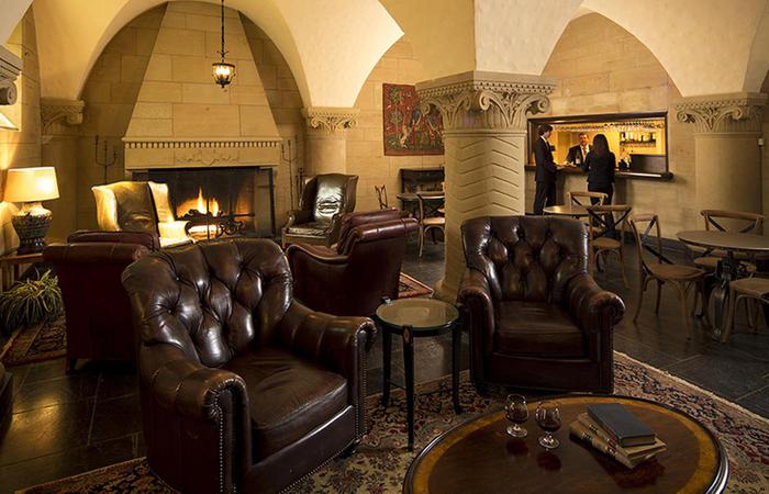 a room with leather chairs and a fireplace