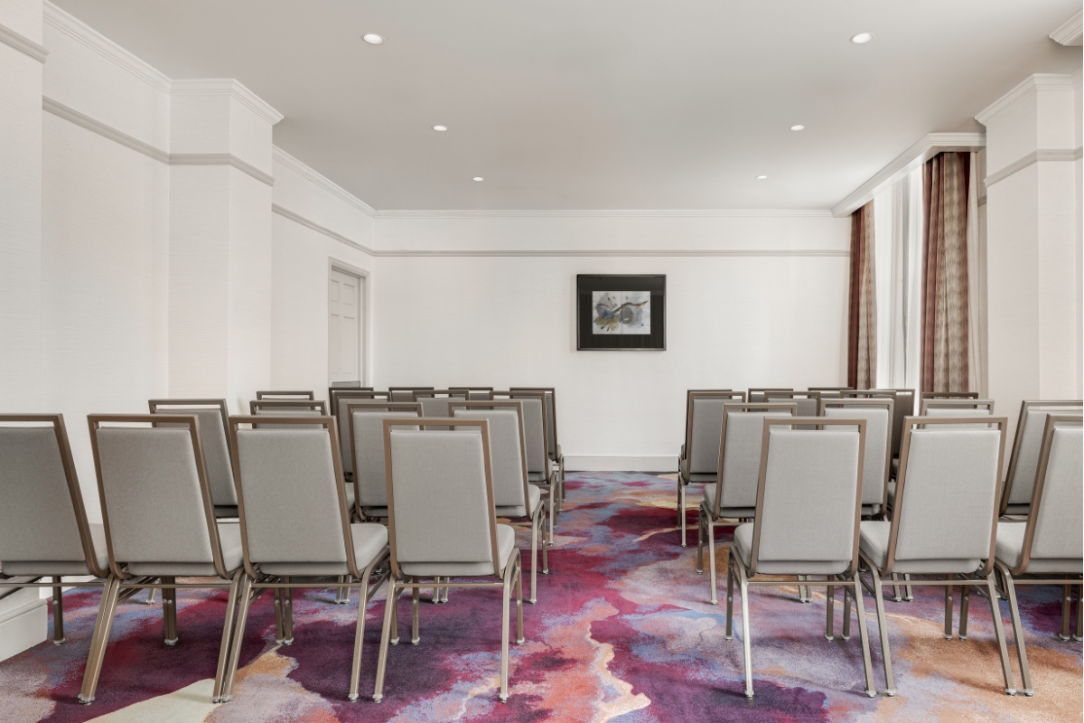 a room with chairs and a painting on the wall