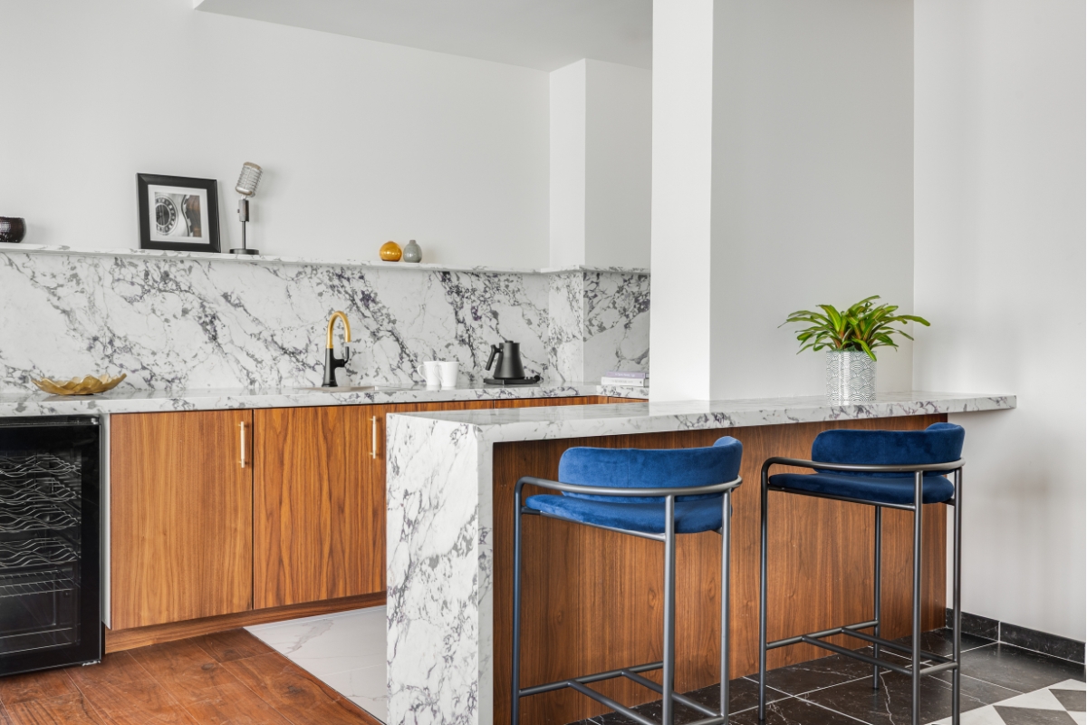 a kitchen with marble countertops and blue stools
