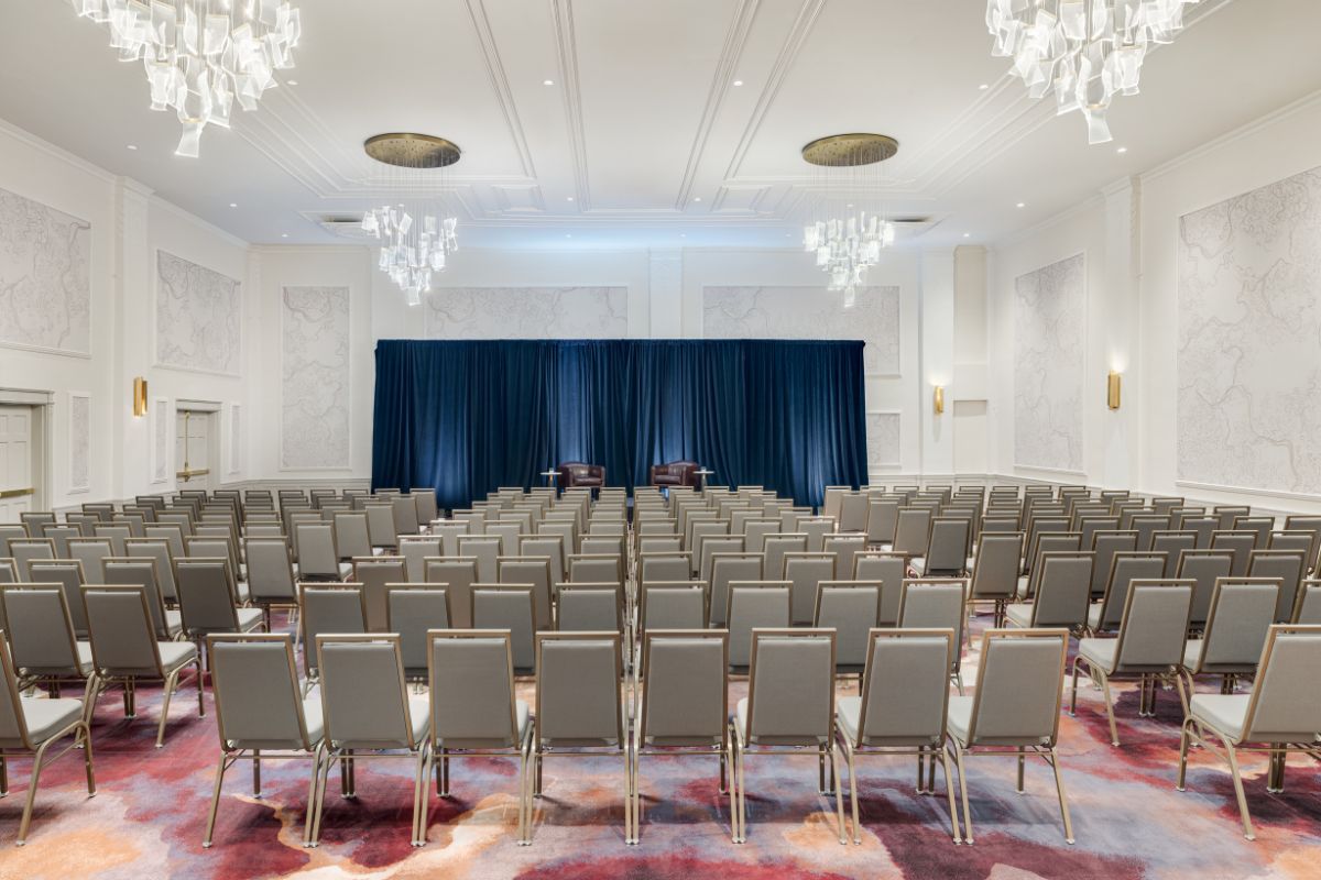 a room with many chairs and a blue curtain