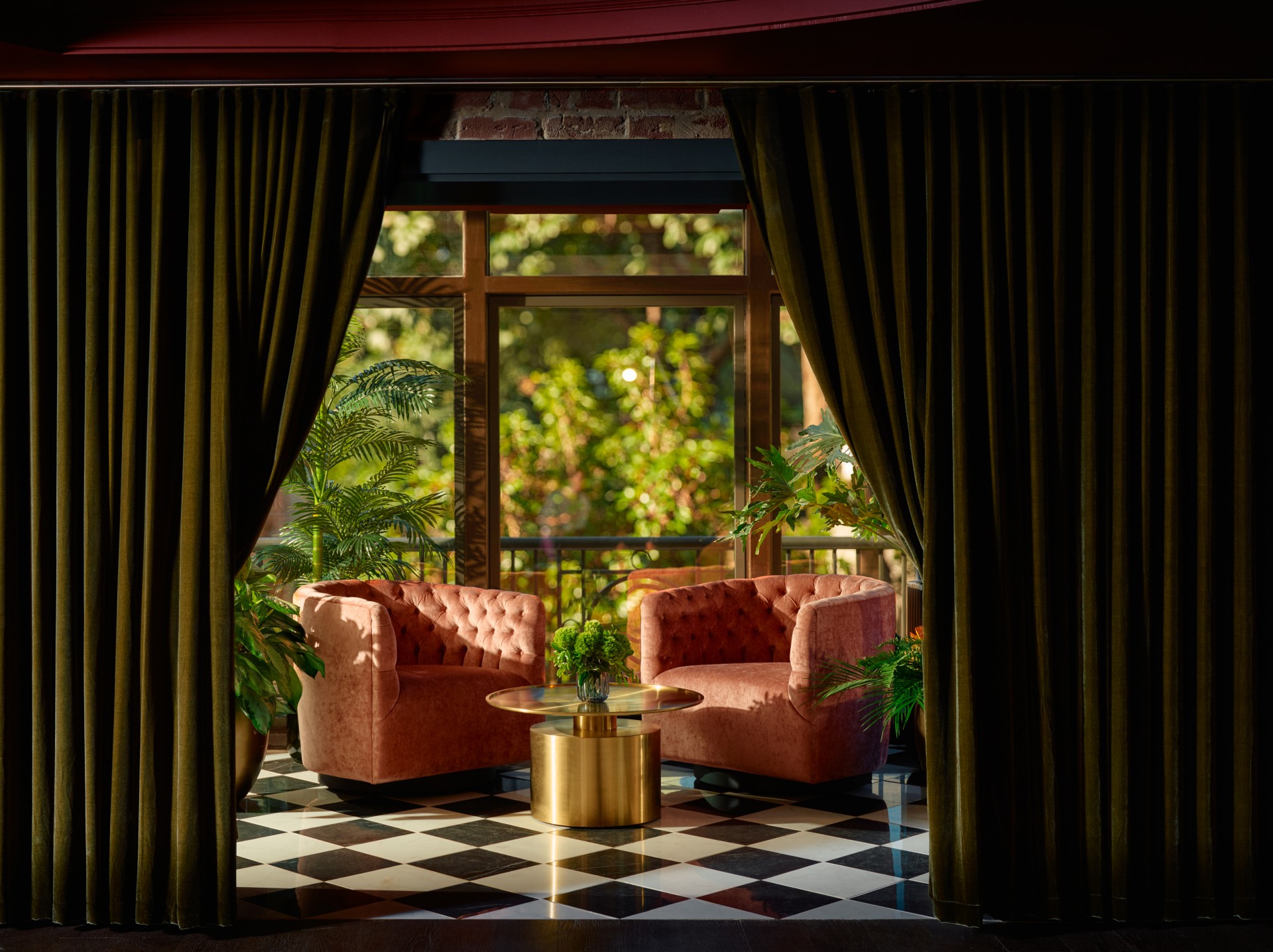 a room with a black and white checkered floor and two pink chairs