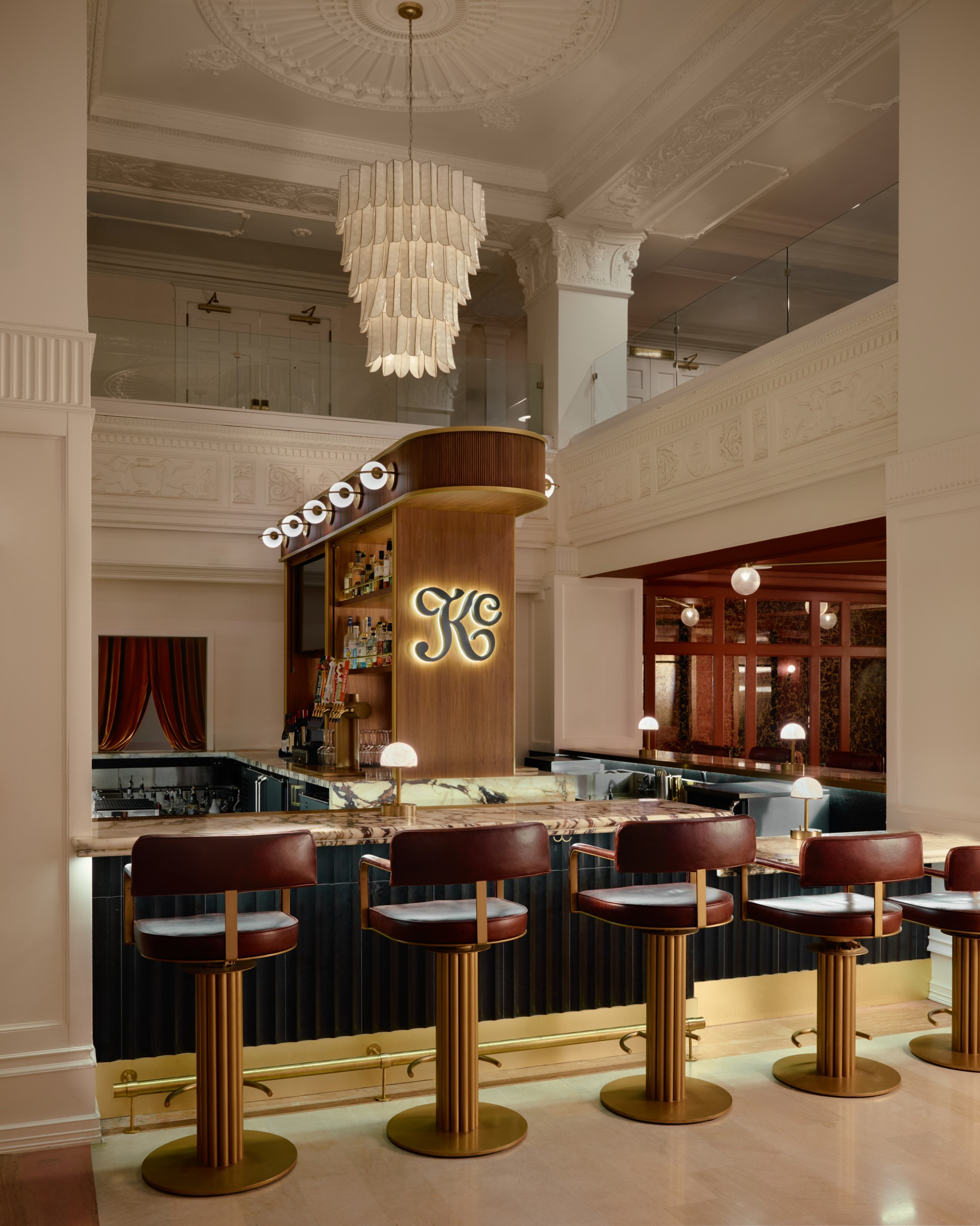 a bar with chairs and a chandelier