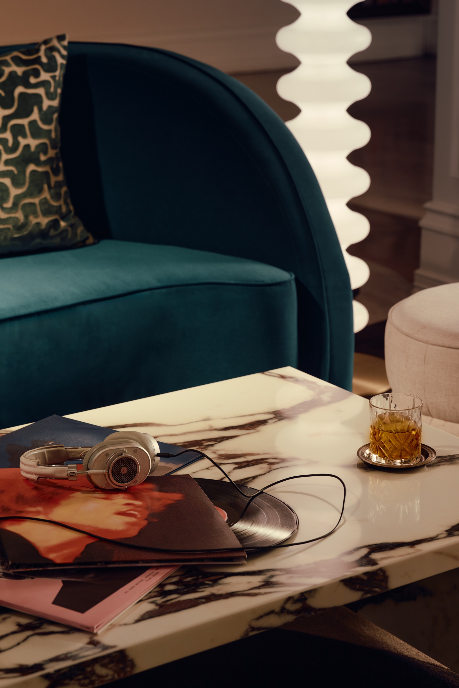 a table with a glass of liquid and headphones on it