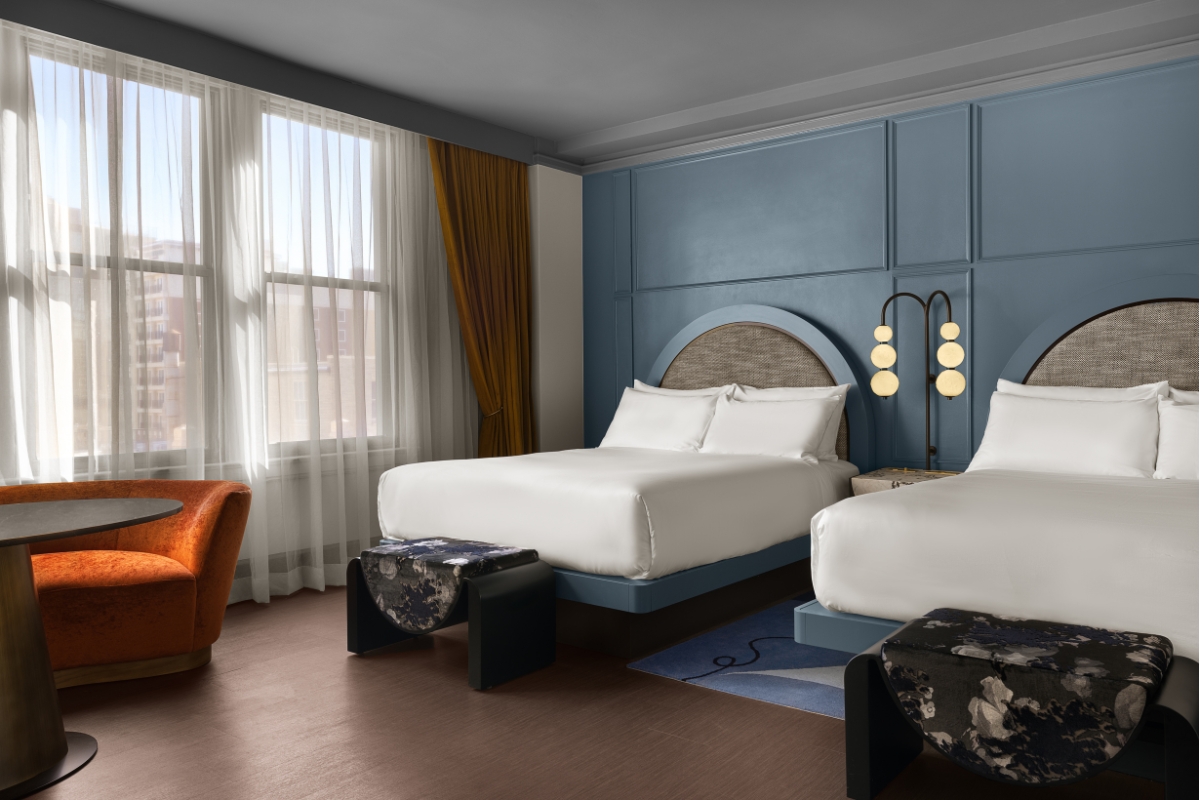 a room with two beds and a chair