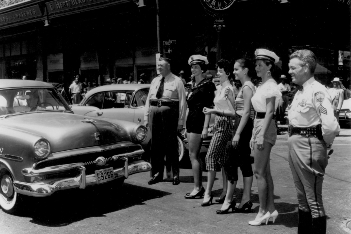 a group of women standing in front of a car