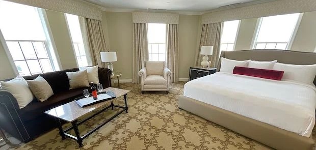 a room with a bed and chairs