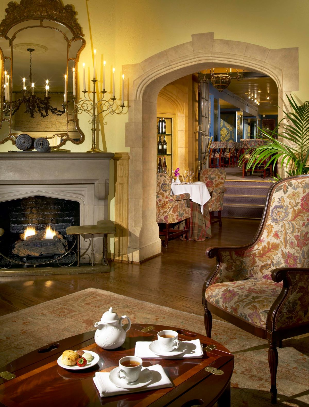 a room with a fireplace and a table with tea cups and a teapot