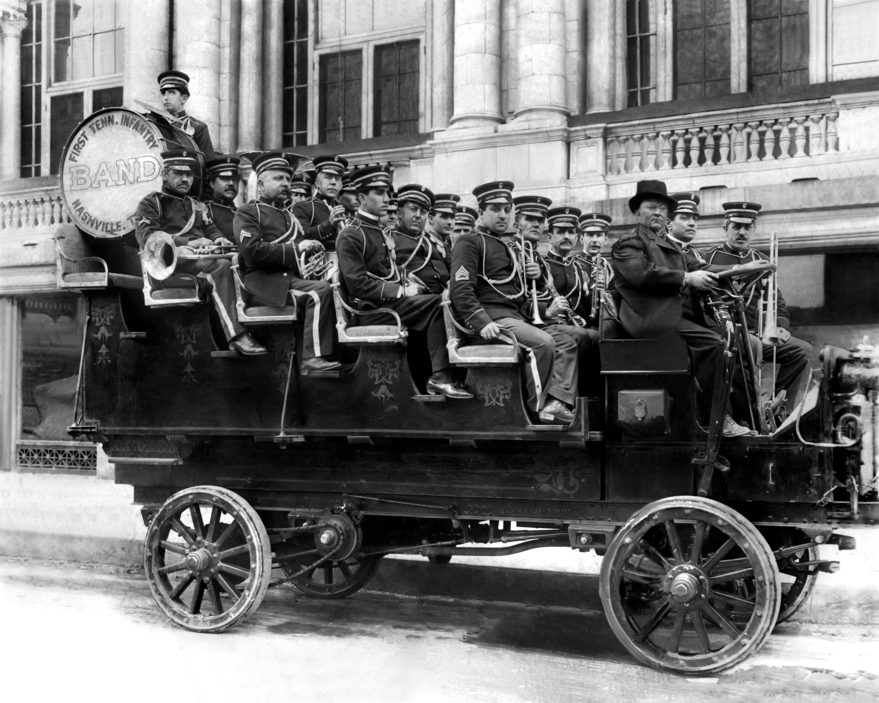 a group of men in military uniforms riding on a vehicle