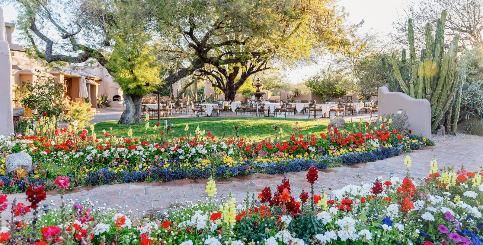 a garden with tables and chairs in the background