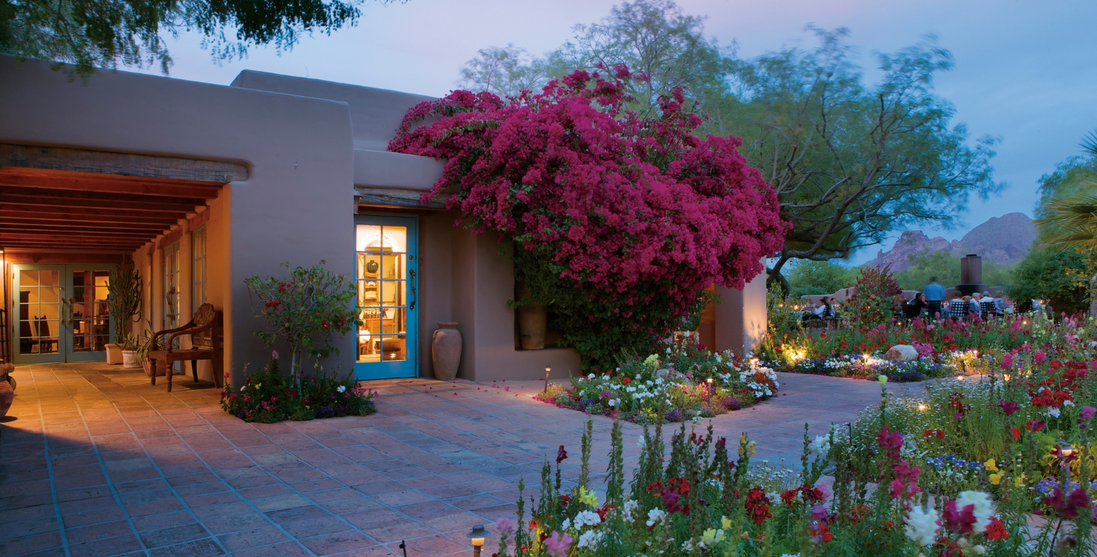 a building with flowers and a blue door