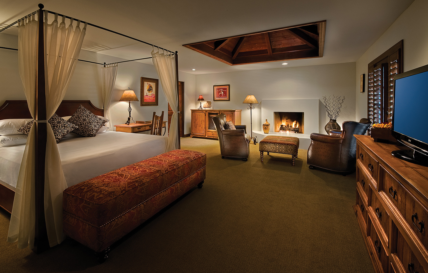 a room with a bed and chairs