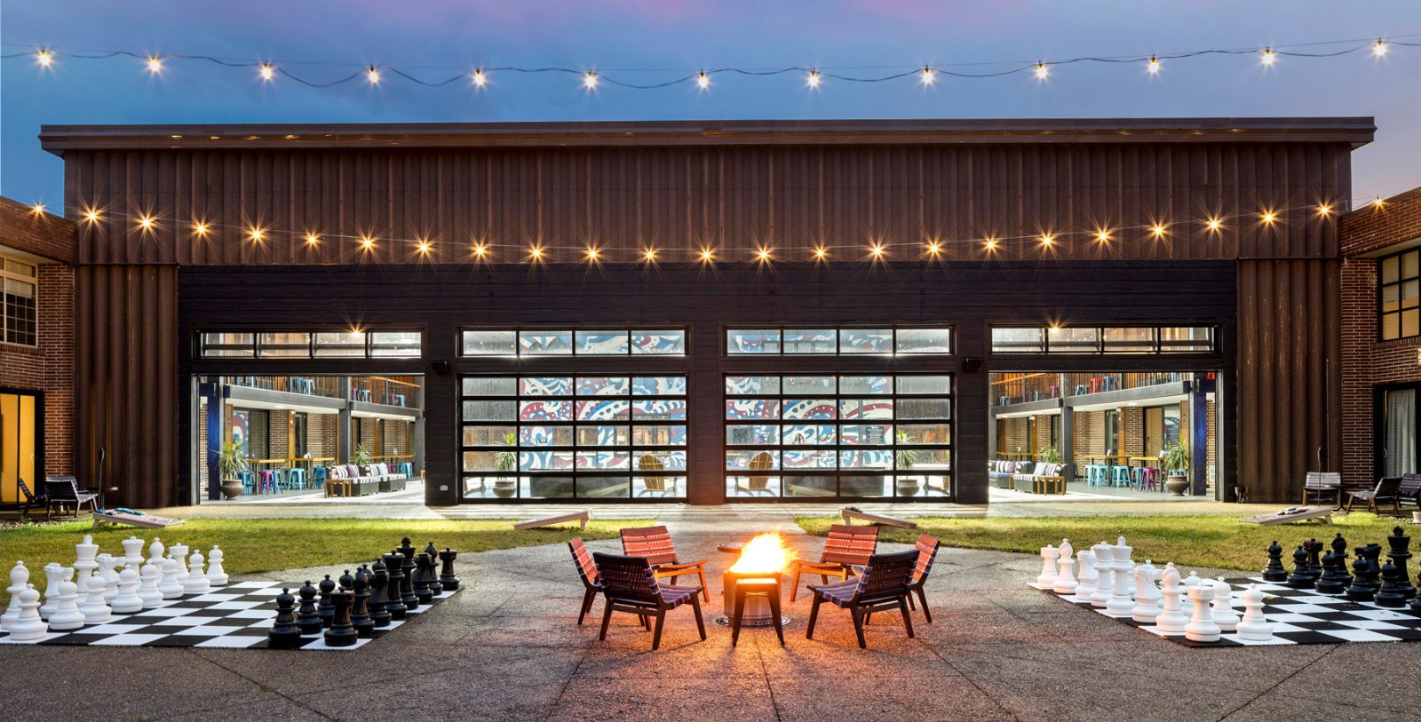 a fire pit with chairs and chess pieces in front of a building