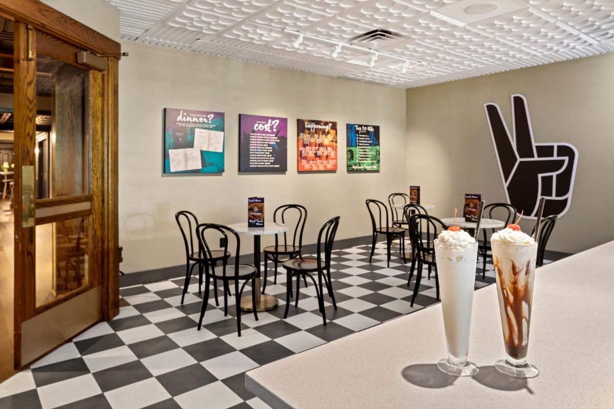 a room with tables and chairs and a table with a couple of milkshakes