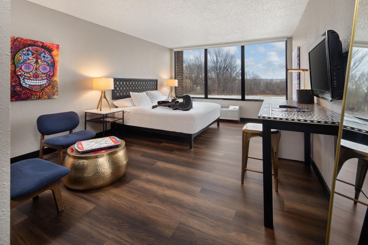a room with a bed and a desk and chairs