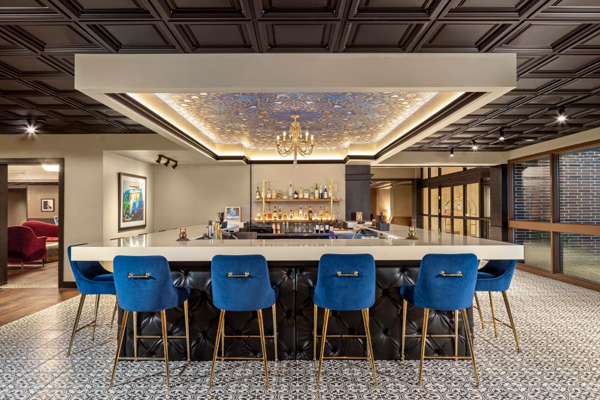 a bar with blue chairs and a chandelier