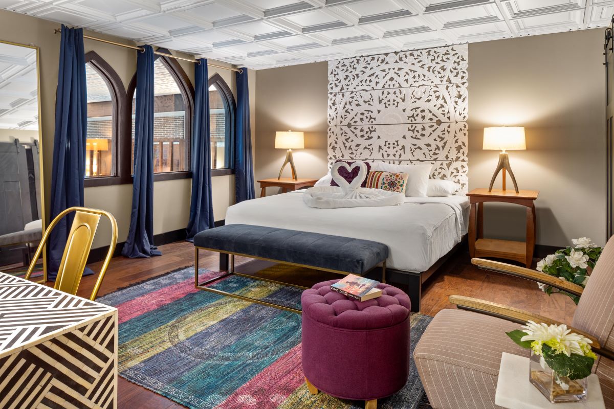 a bedroom with a bed and a colorful rug