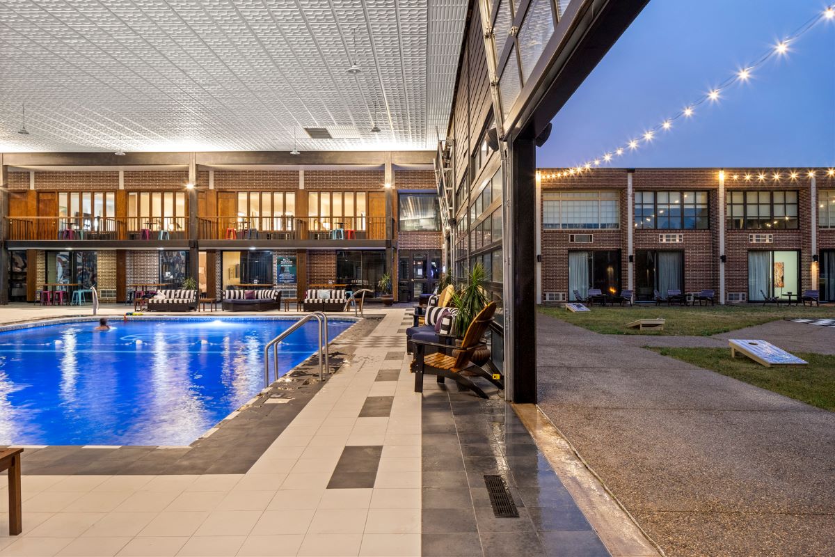 a pool with chairs and a building