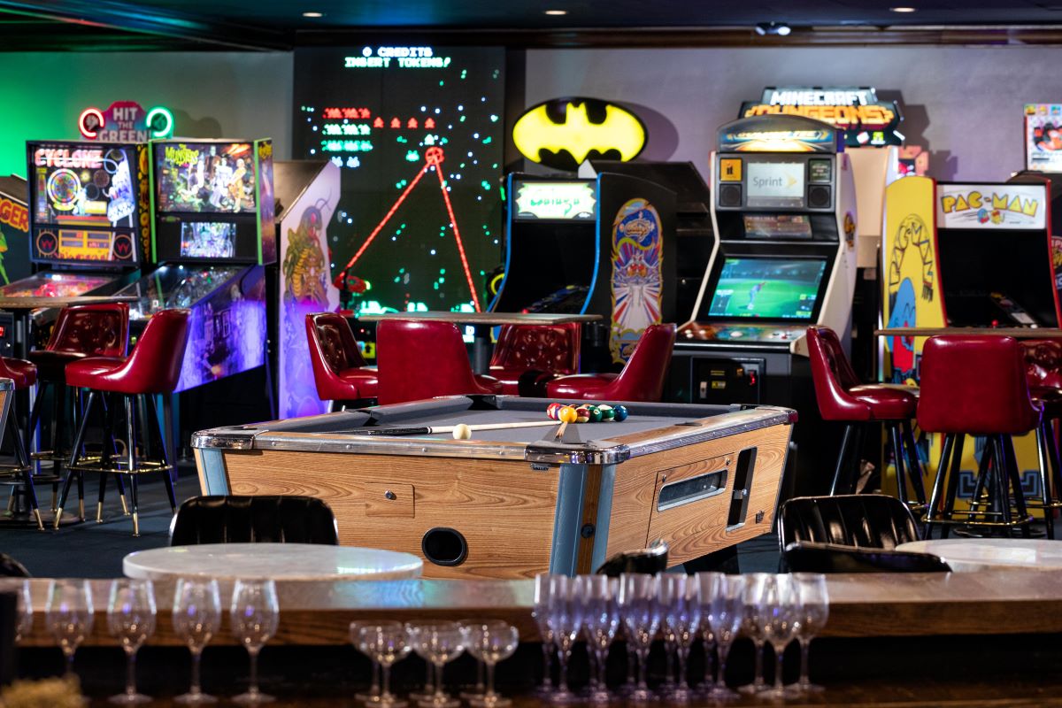 a pool table in a room with arcade games