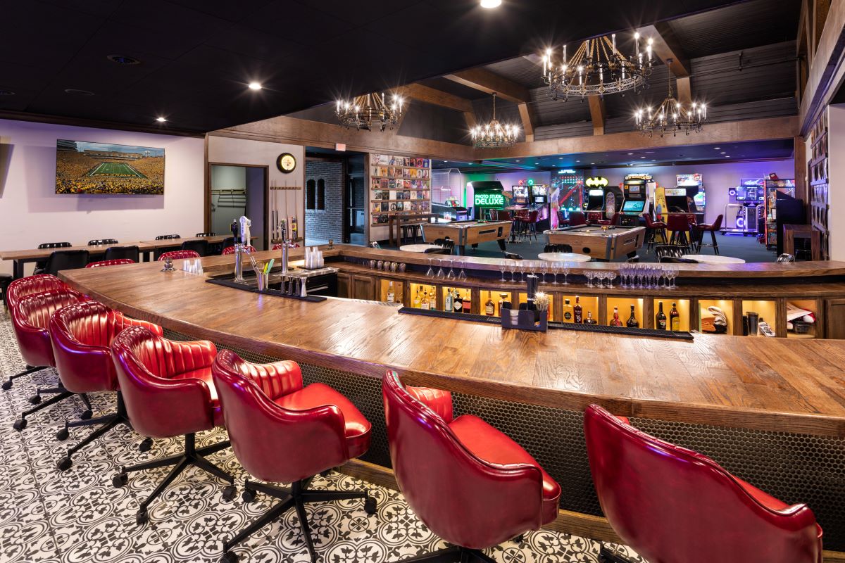 a bar with red chairs and pool tables