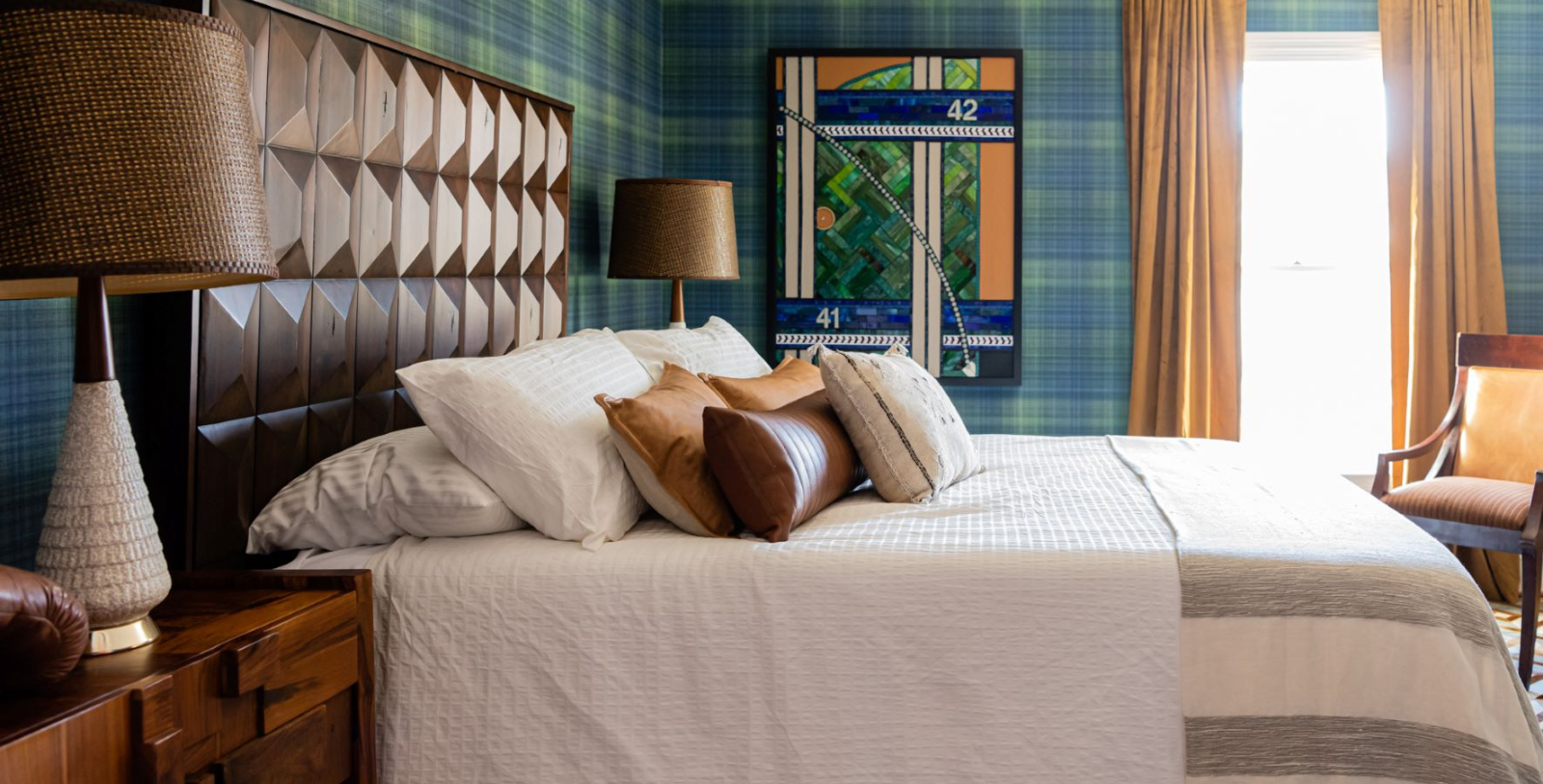 a bed with pillows and a lamp in a room