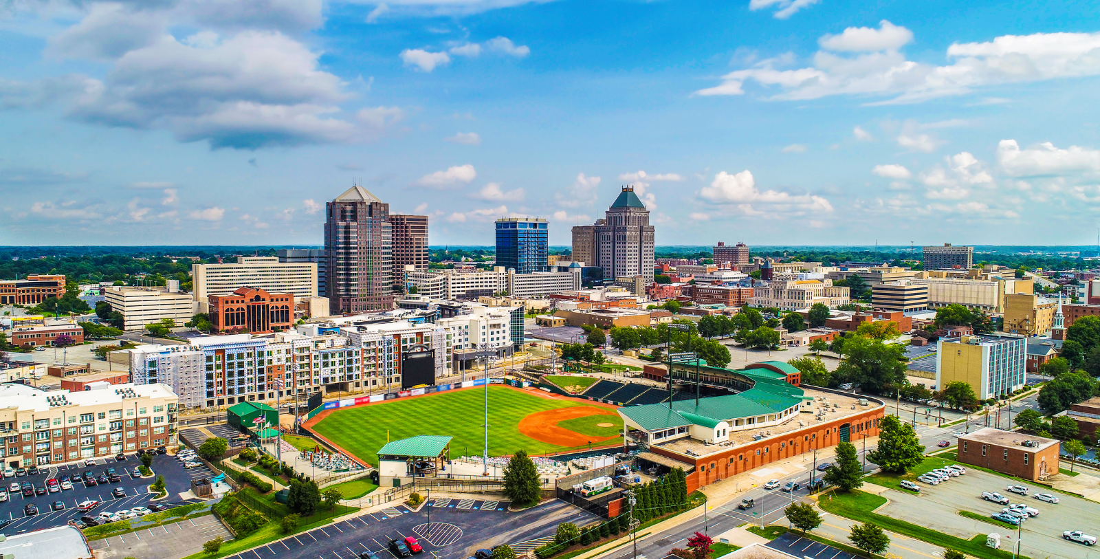 a baseball field and buildings in a city