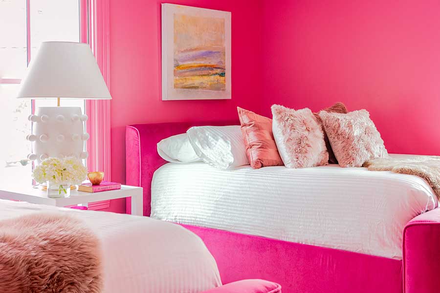 a room with pink walls and a bed