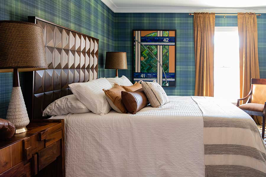 a bed with pillows and a lamp in a room