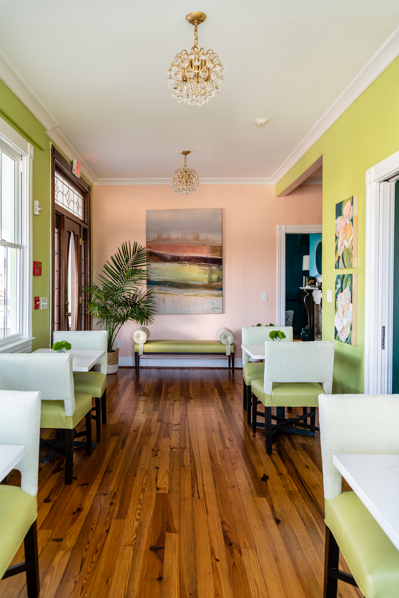 a room with green walls and white tables and chairs