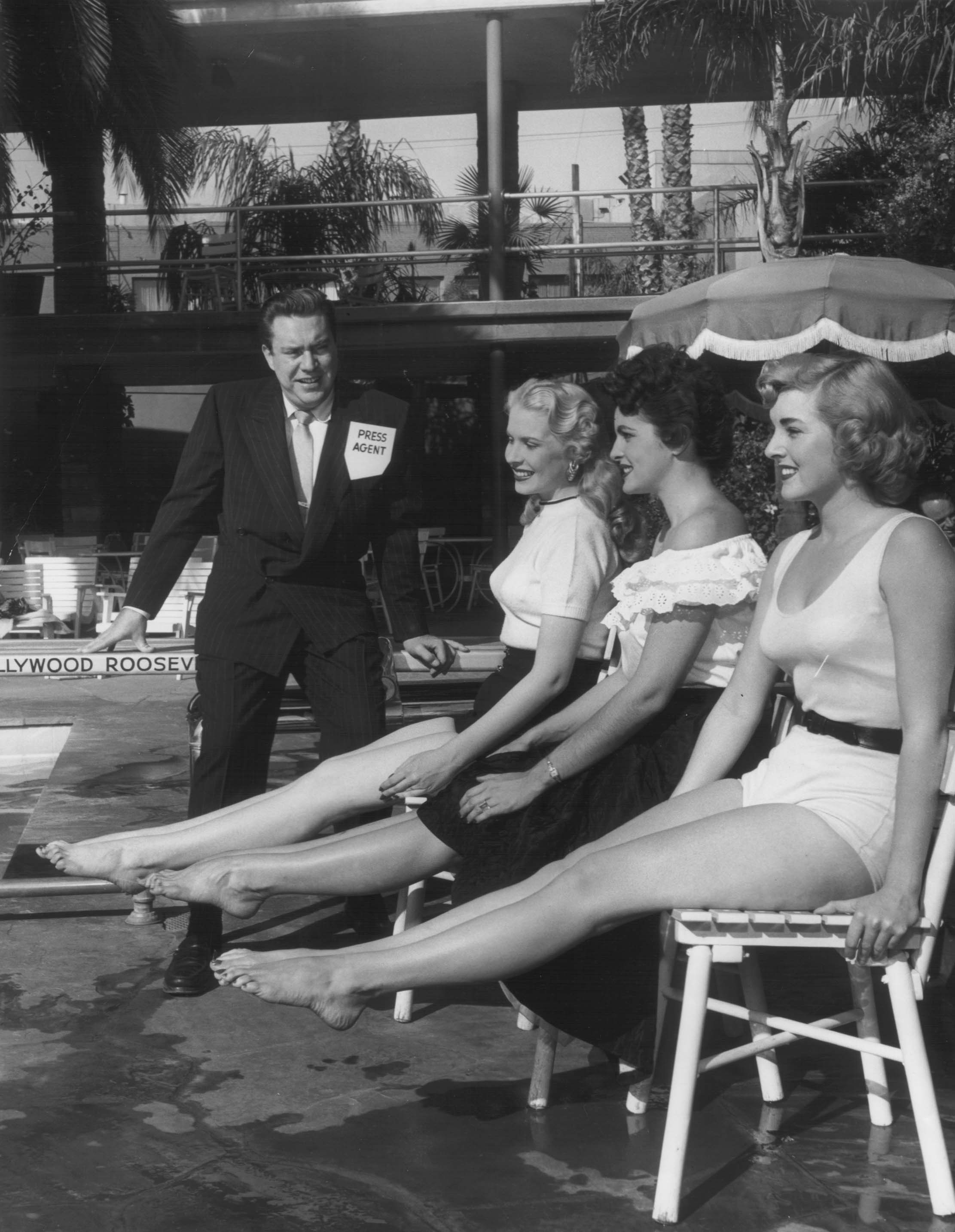 a group of women sitting on chairs by a pool
