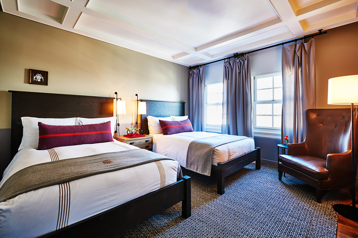 a room with two beds and a chair