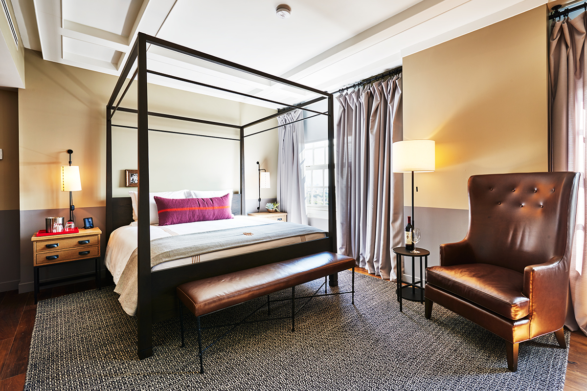 a room with a bed and a leather chair