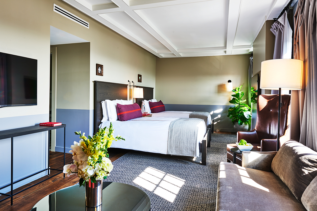 a room with two beds and a chair