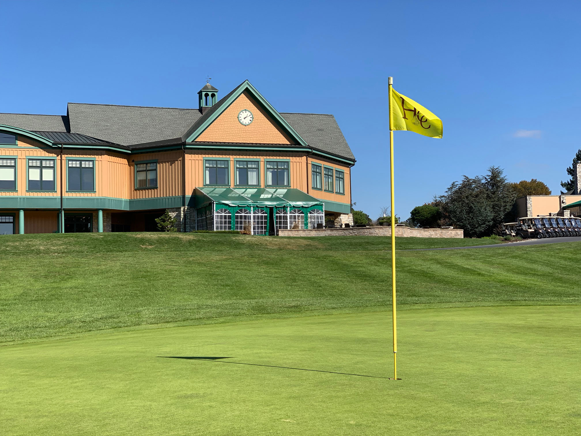 a building with a flag on the corner of a golf course