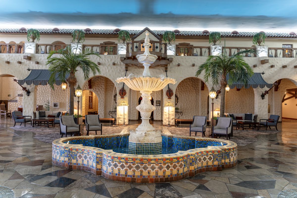 a fountain in a room with palm trees