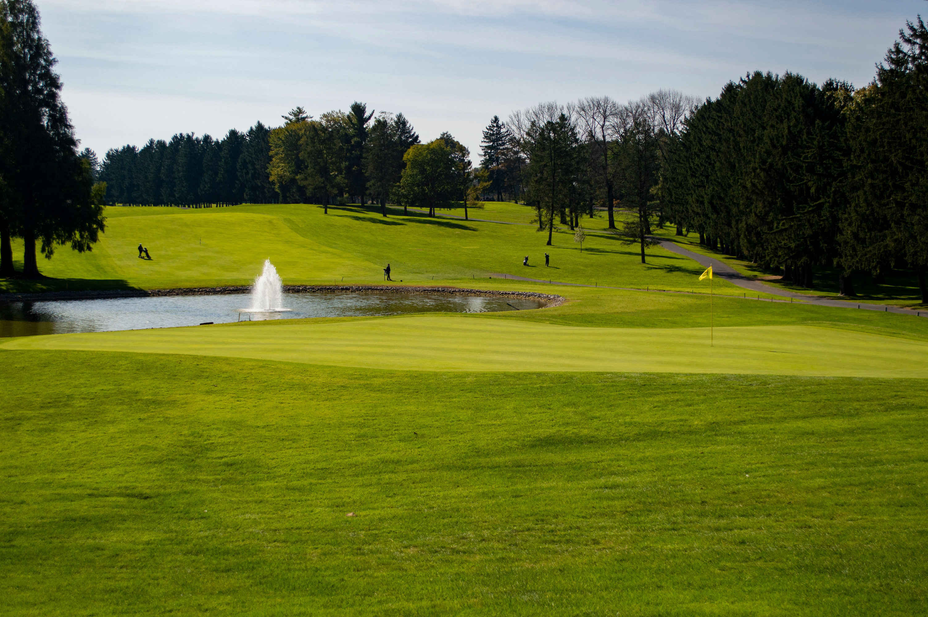 a golf course with a fountain in the middle