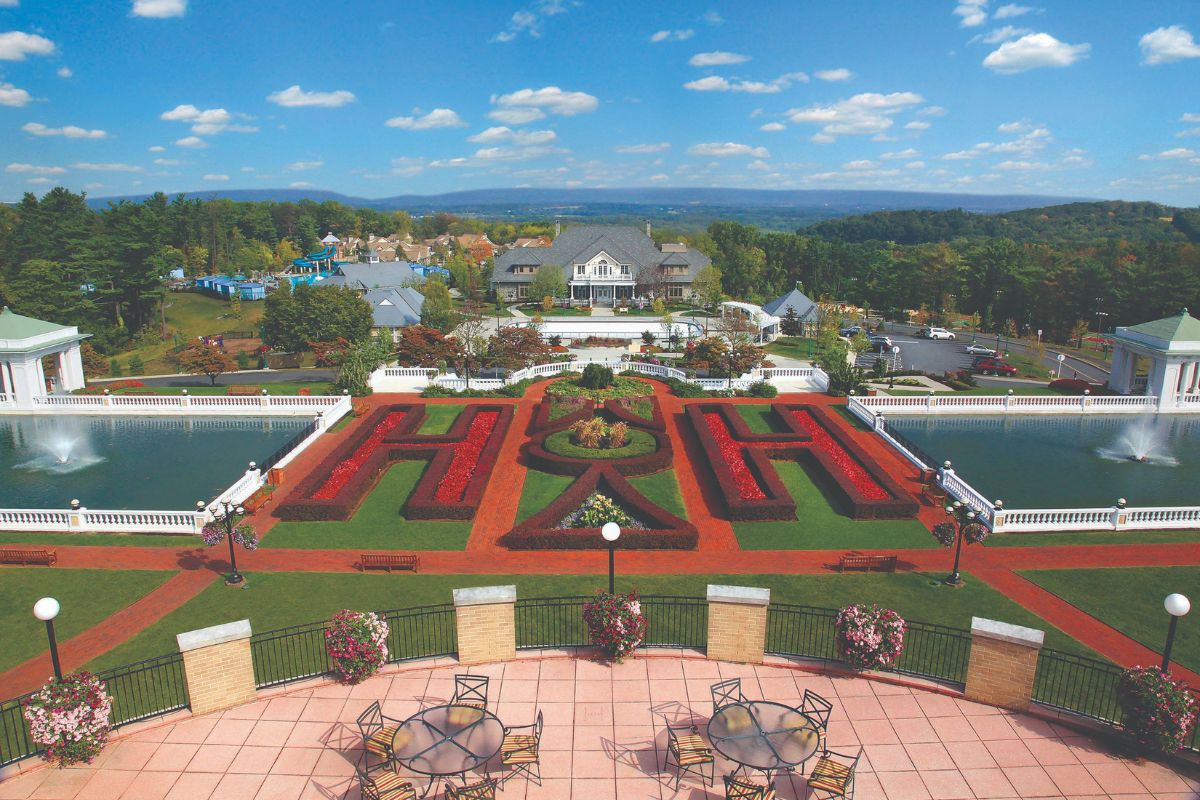 a view of a garden with a pool and a house in the background