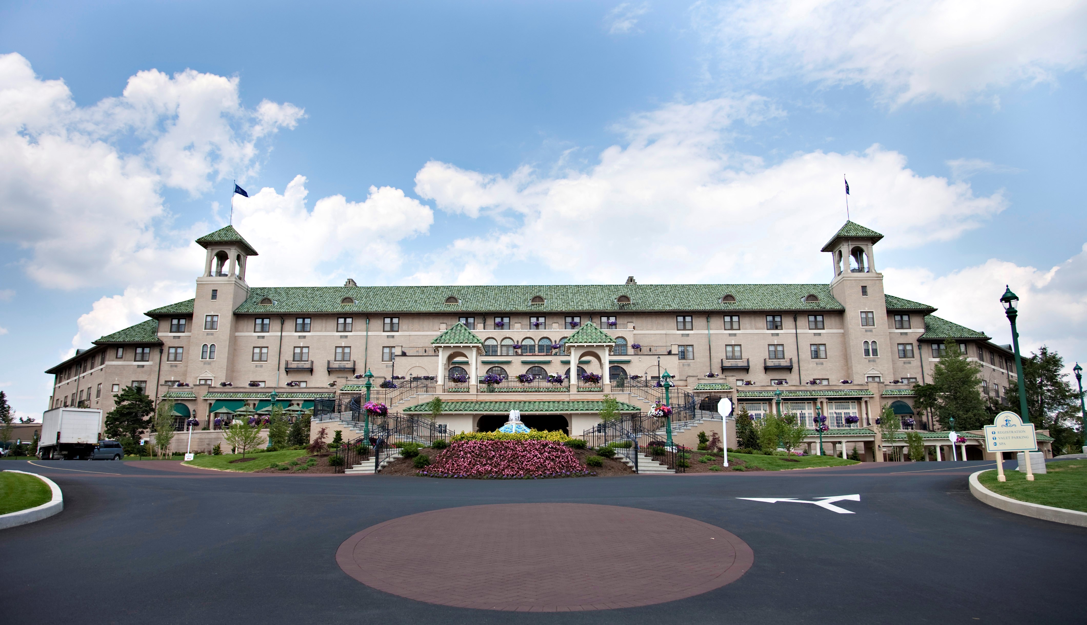 a large building with a circular road and a parking lot with The Hotel Hershey in the background
