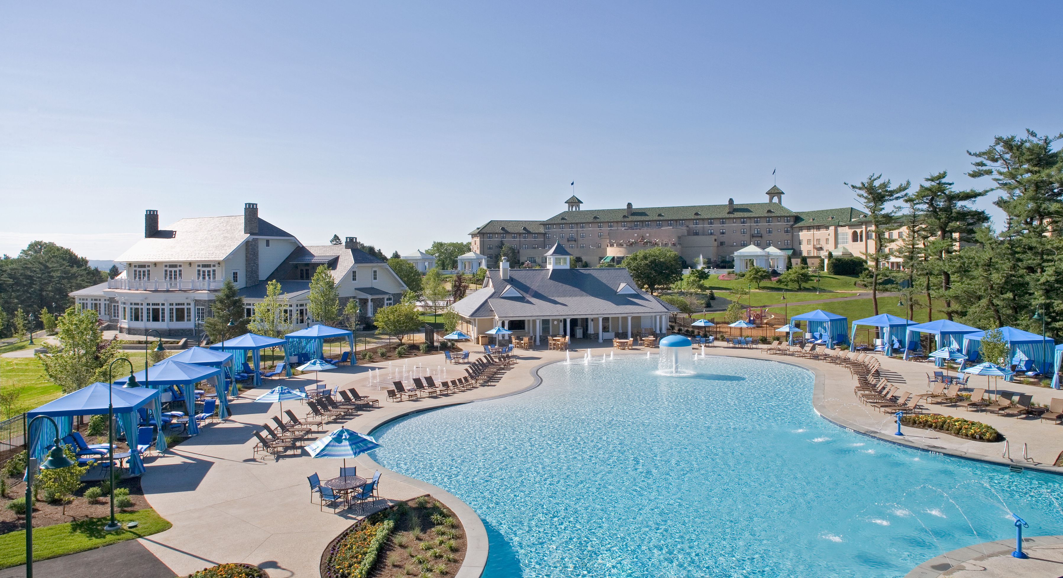 a swimming pool with a large fountain and chairs