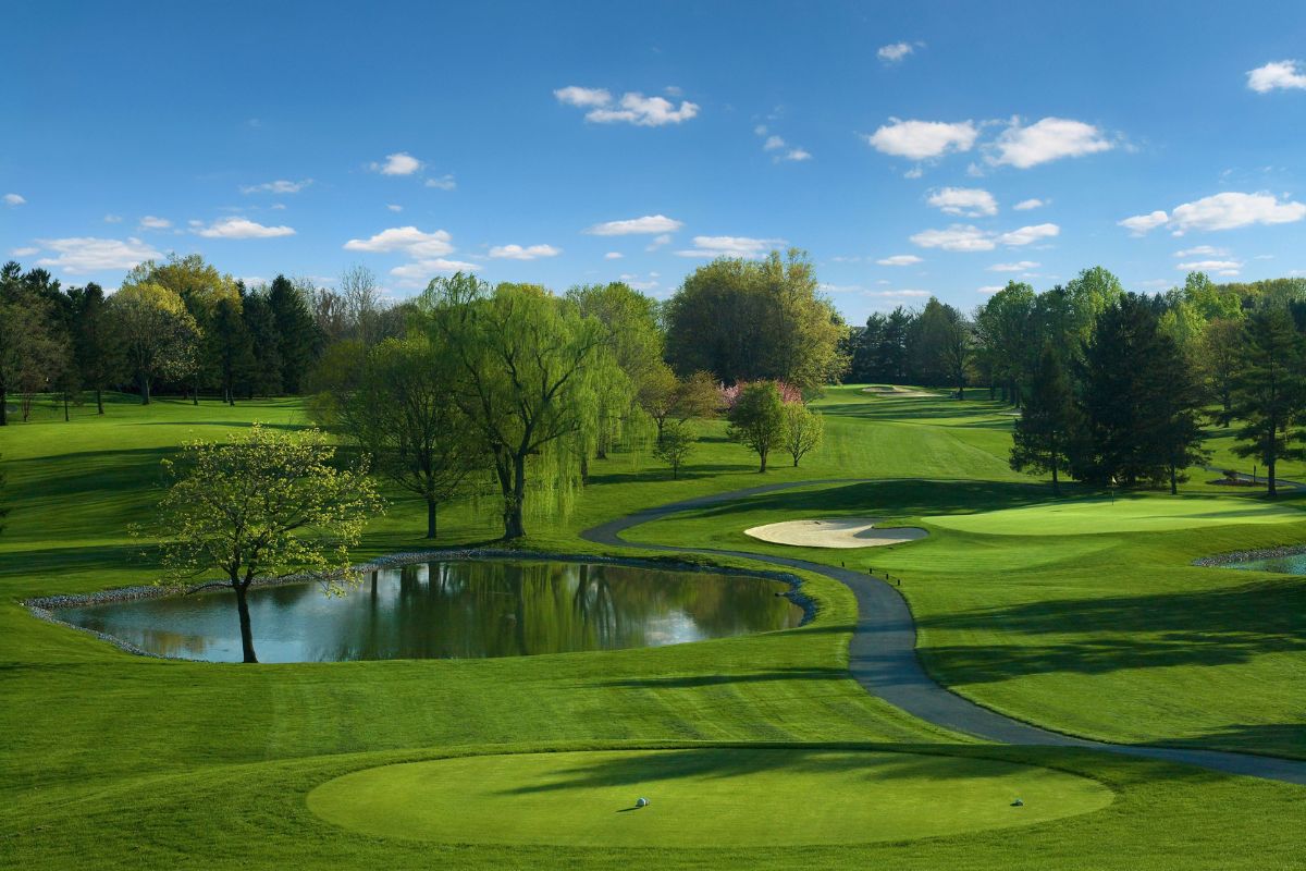 a golf course with a pond and trees