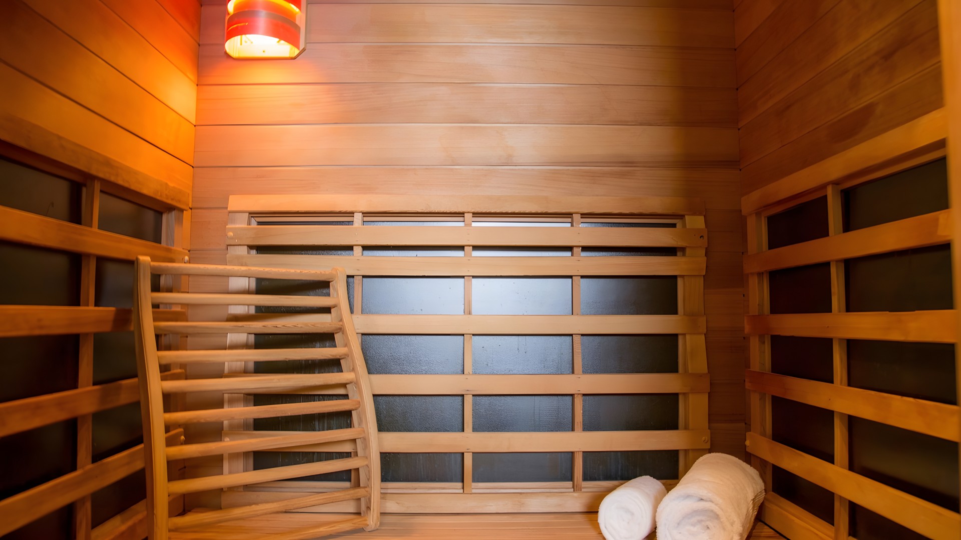 a wooden bench and towels in a sauna