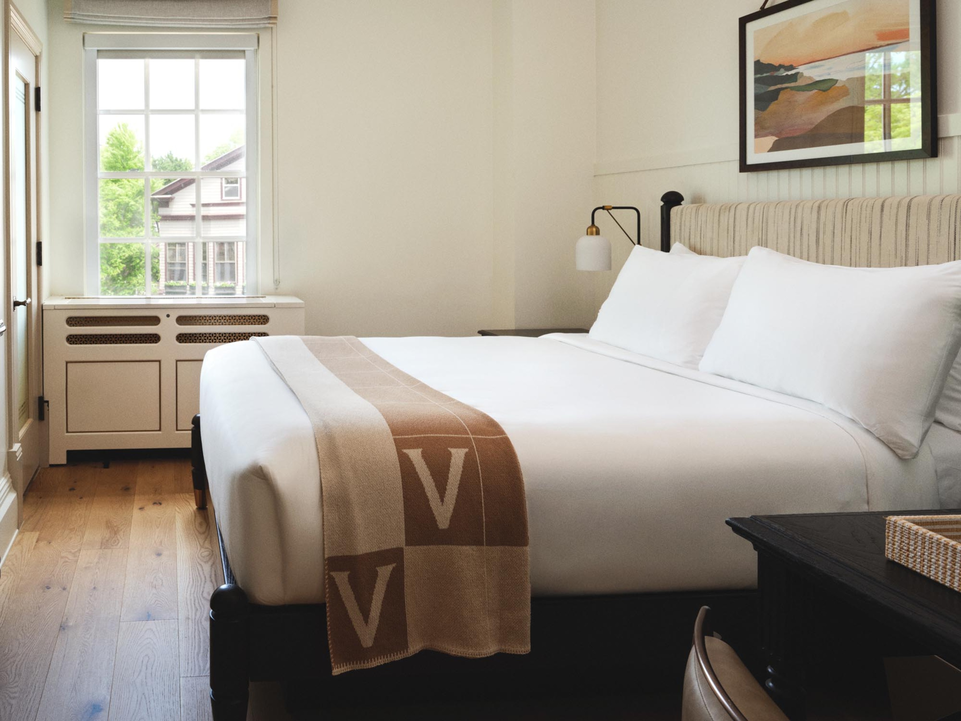 a bed with white sheets and a brown blanket