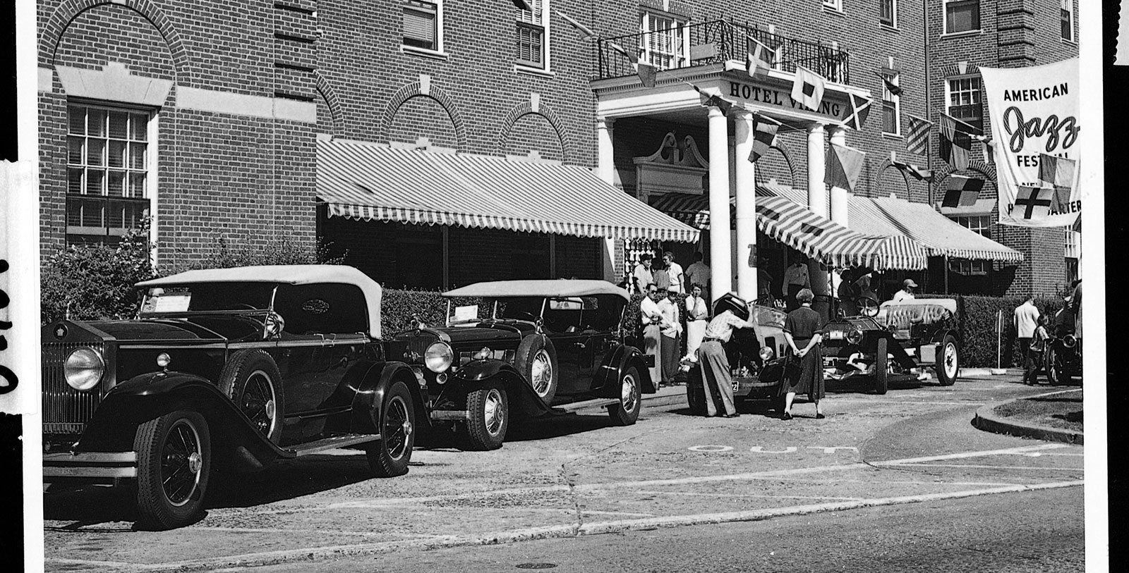 a group of people standing in front of a hotel