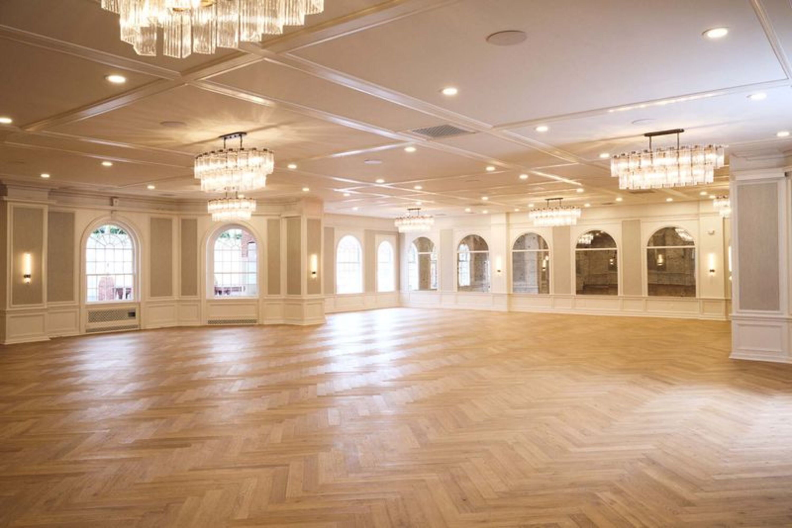 a large room with a wood floor and chandeliers
