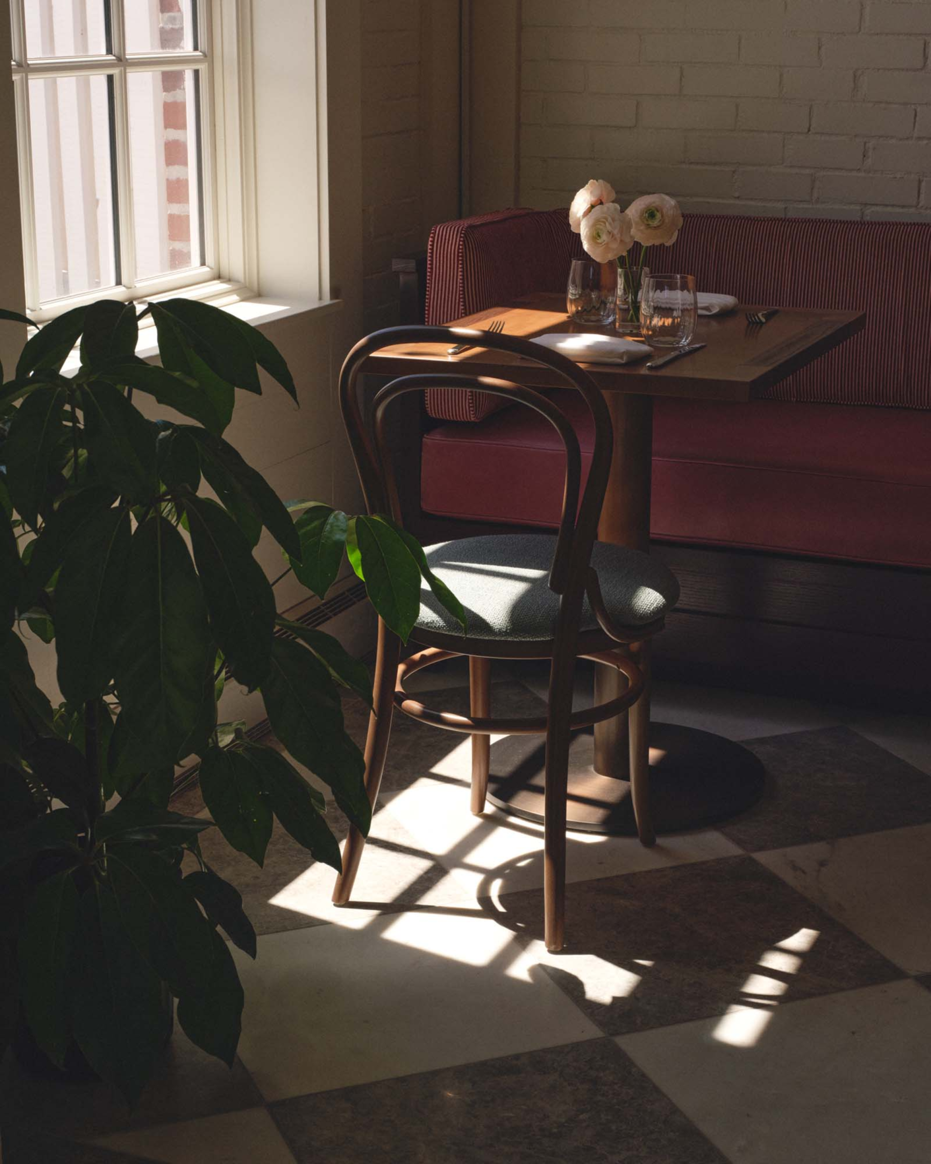 a table with a red couch and a flower vase on it
