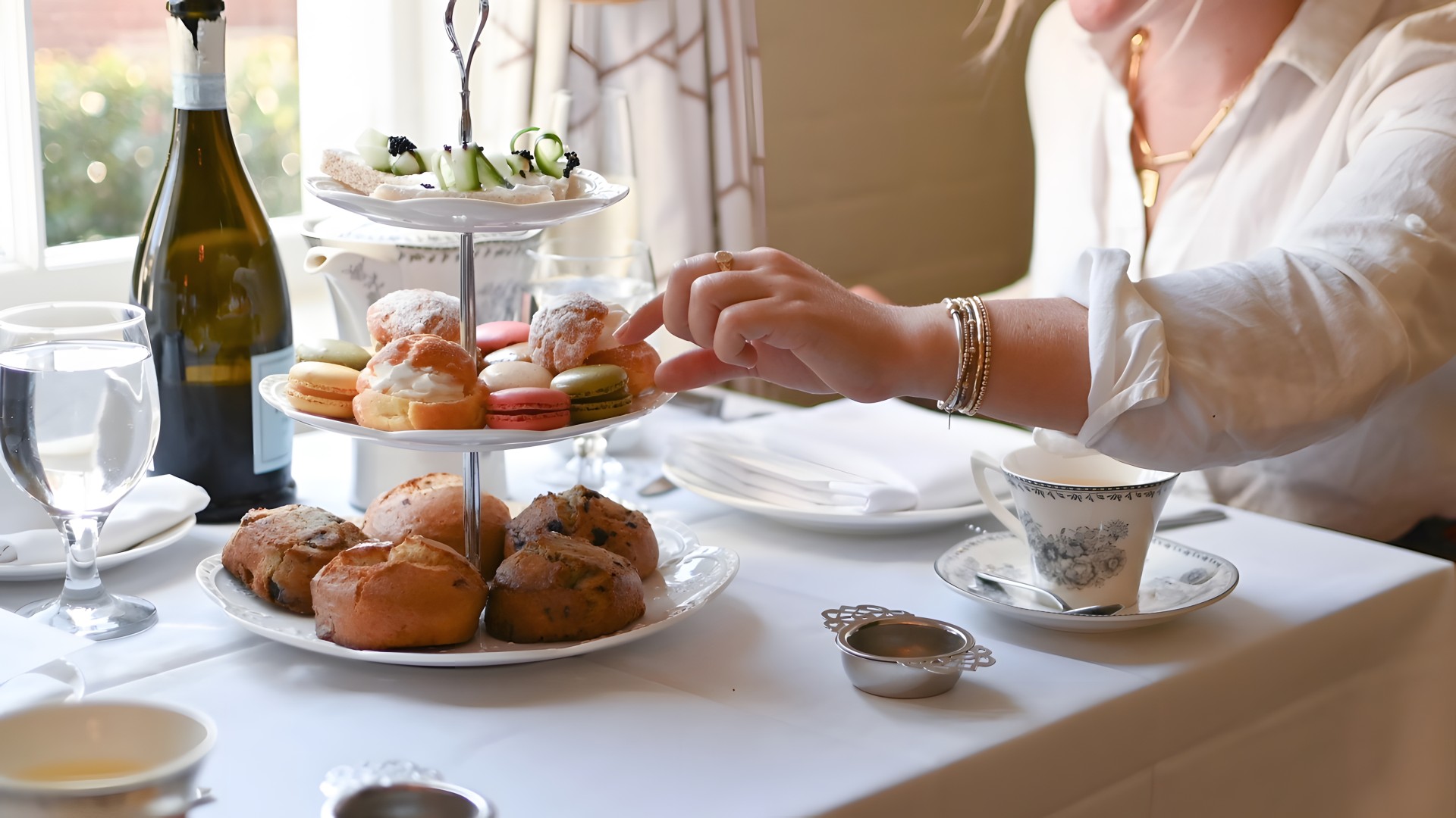 a woman reaching for a plate of pastries